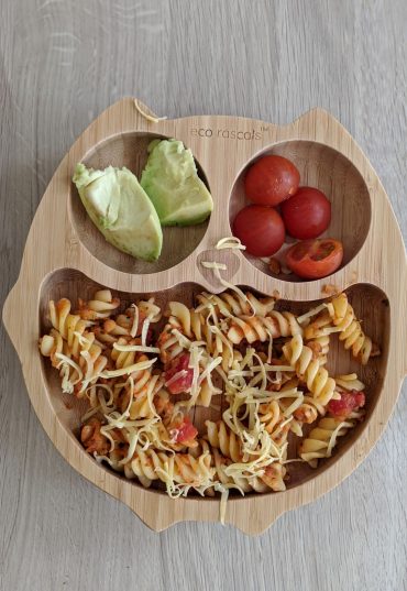 Bamboo owl shaped plate with pasta, avocado and tomatoes